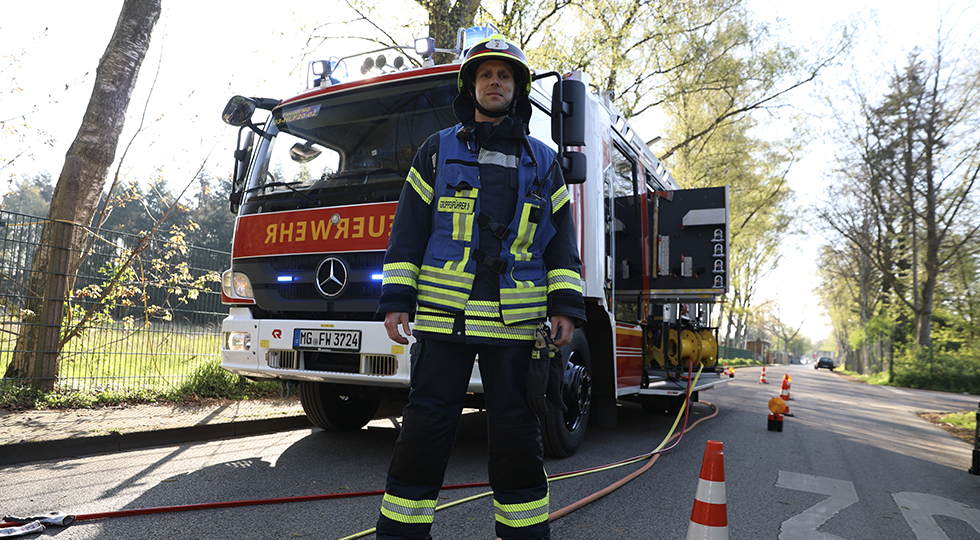 Brandoberinspektor im Training vor einem Feuerwehrwagen